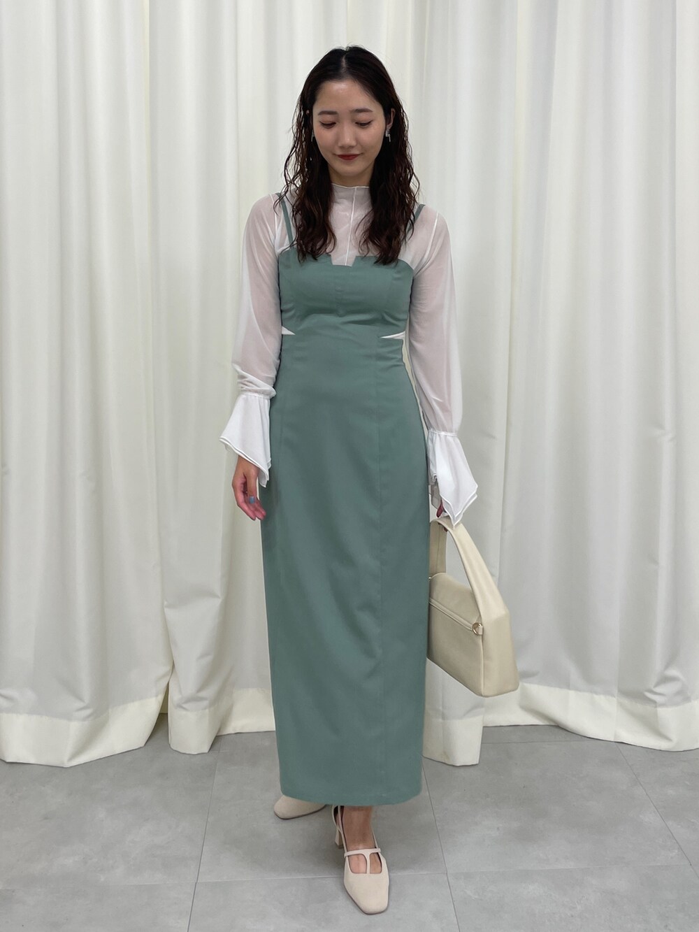 グリーン系のワンピース、ホワイト系のパンプスを着用したレディースの春コーディネートの4枚目の写真