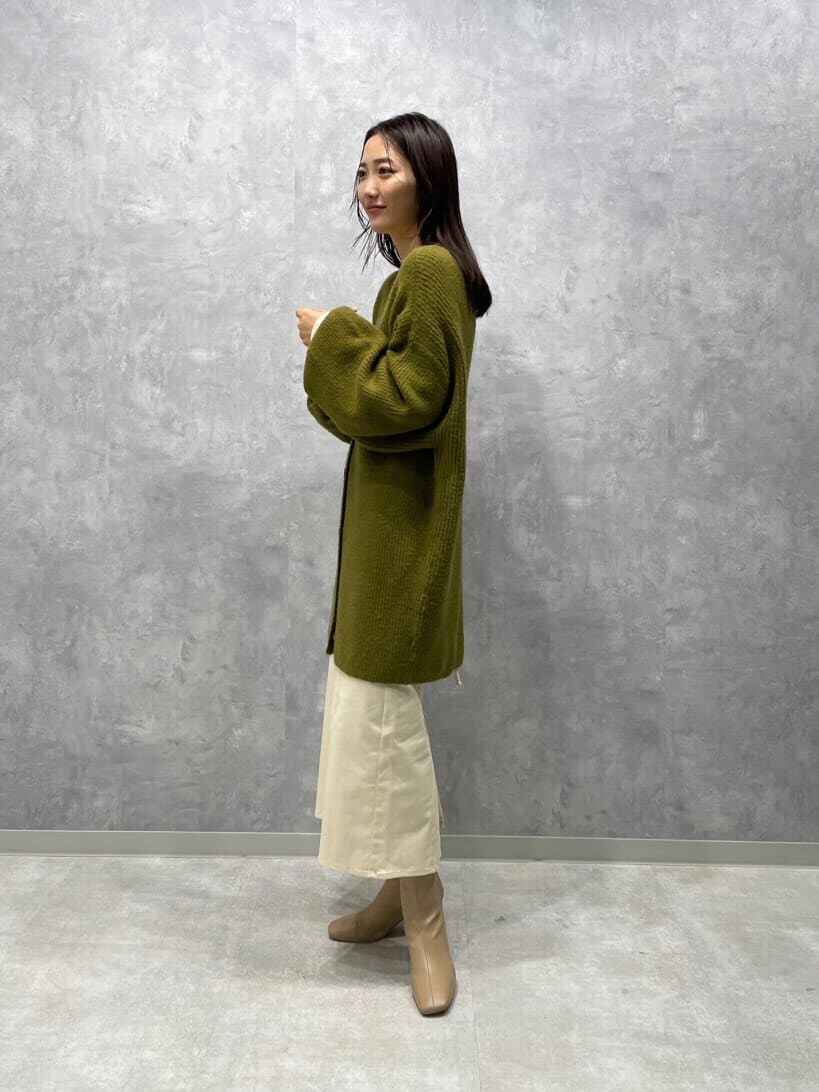 ベージュ系のブーツ、ホワイト系のニット/セーター、ホワイト系のスカートを着用したレディースの秋コーディネートの4枚目の写真