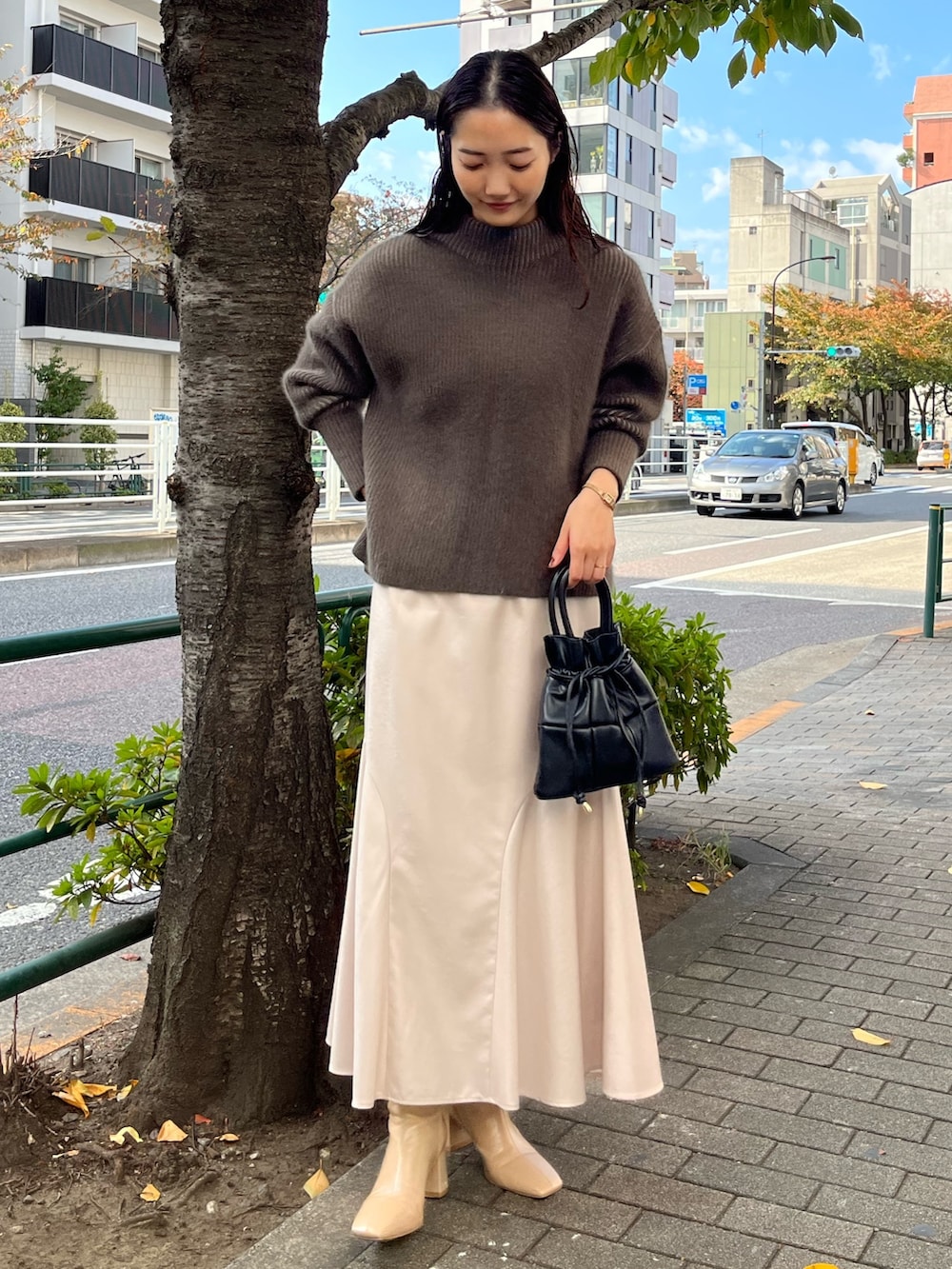 ベージュ系のニット/セーター、ベージュ系のブーツ、グレー系のスカートを着用したレディースの冬コーディネートの2枚目の写真