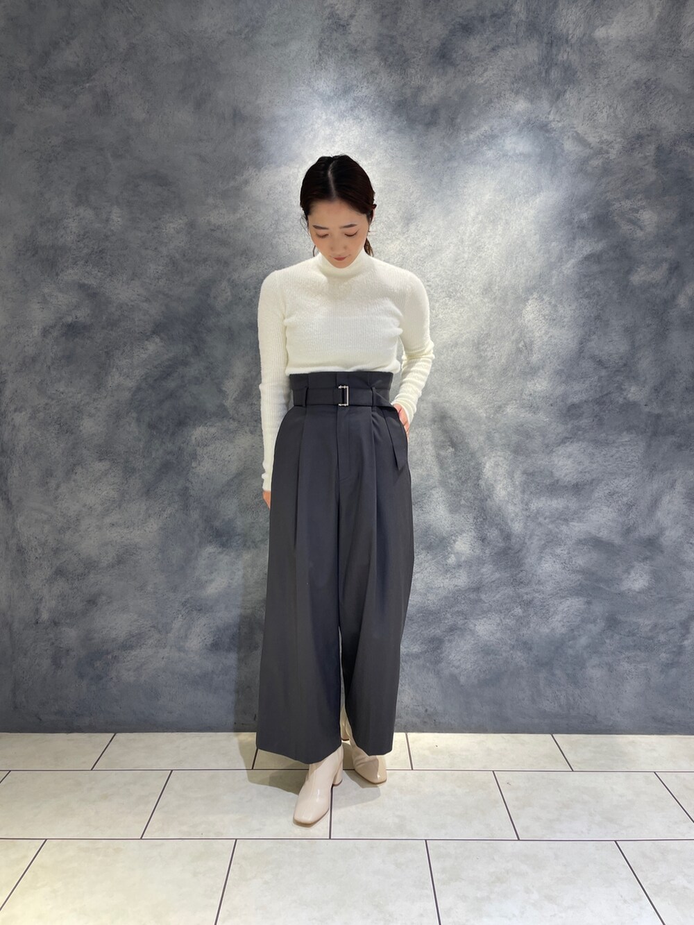グレー系のその他パンツ、ホワイト系のニット/セーター、ホワイト系のブーツを着用したレディースの冬コーディネートの4枚目の写真