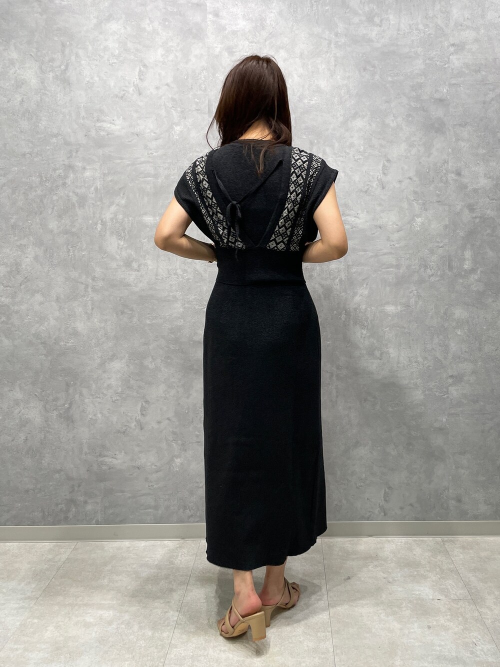 ベージュ系のサンダル、ブラック系のワンピースを着用したレディースの春コーディネートの3枚目の写真