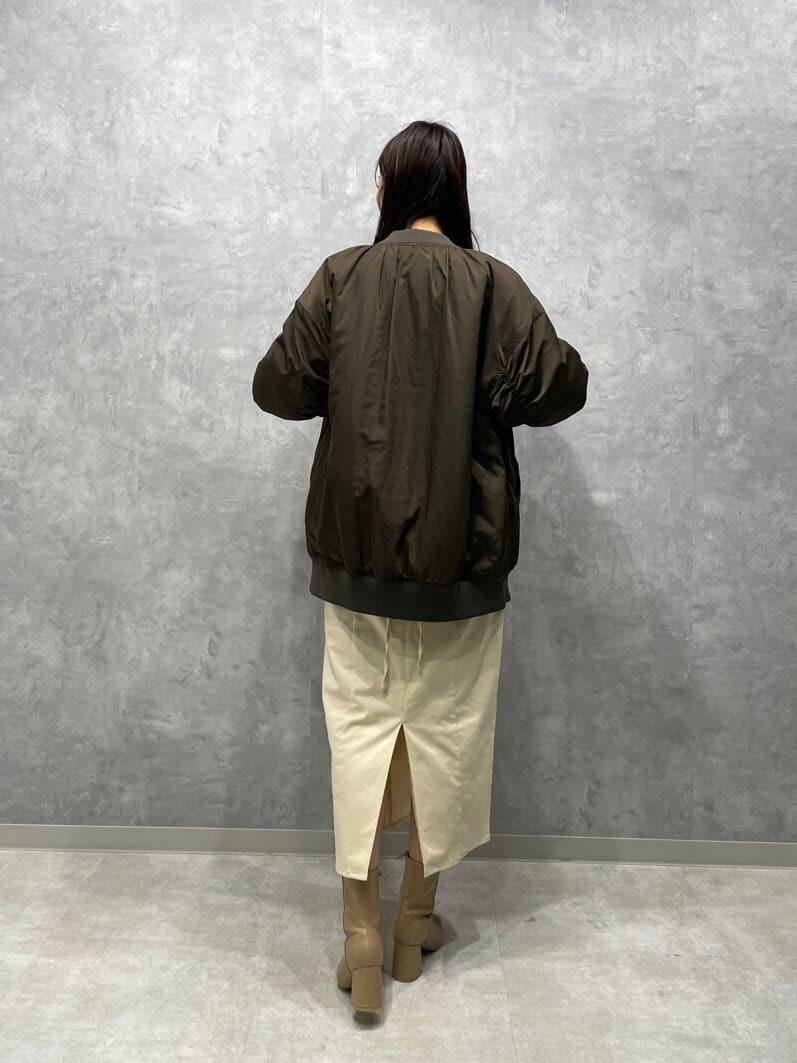 ベージュ系のブーツ、ホワイト系のニット/セーター、ブラウン系のMA-1を着用したレディースの秋コーディネートの6枚目の写真