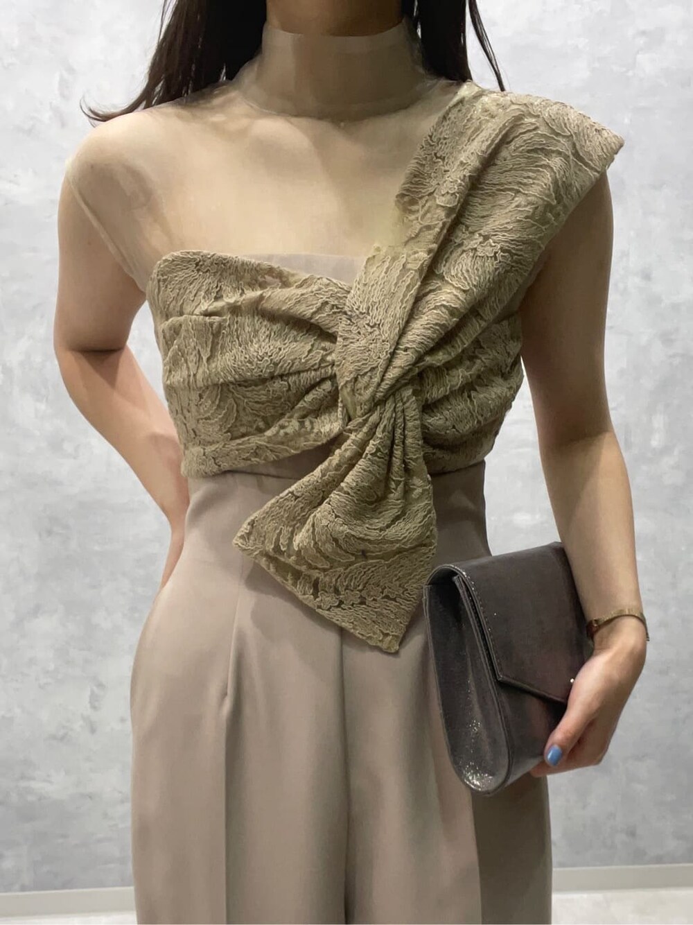 シルバー系のパンプス、シルバー系のクラッチバッグ、ベージュ系のパンツドレスを着用したレディースの夏コーディネートの4枚目の写真