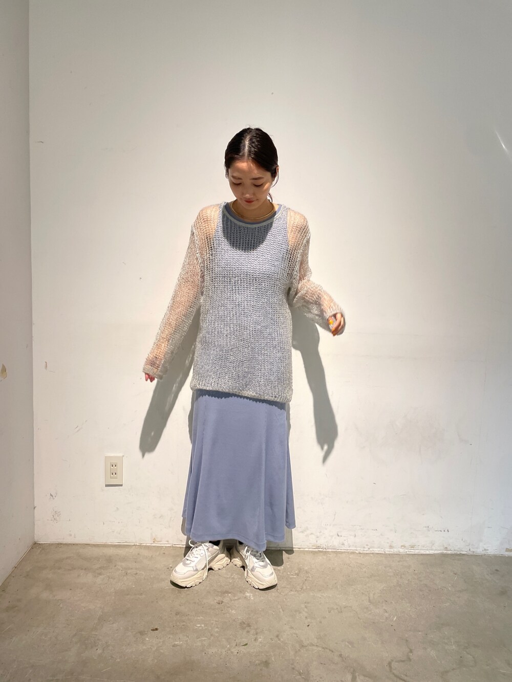 ホワイト系のスニーカー、ブルー系のニット/セーター、ブルー系のワンピースを着用したレディースの春コーディネートの5枚目の写真