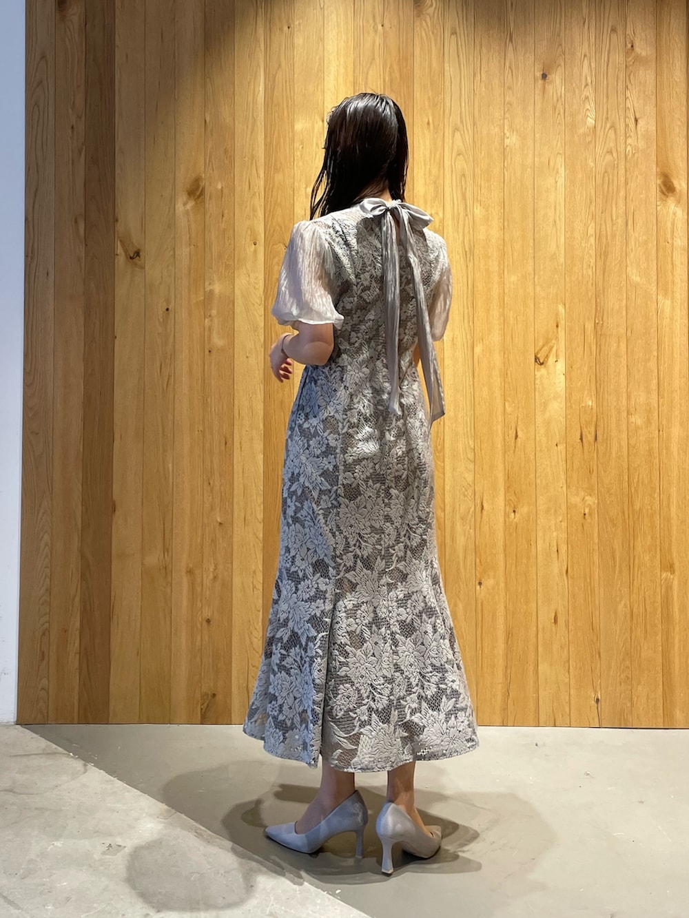 グレー系のパンプス、グレー系のクラッチバッグ、グレー系のドレスを着用したレディースの冬コーディネートの5枚目の写真