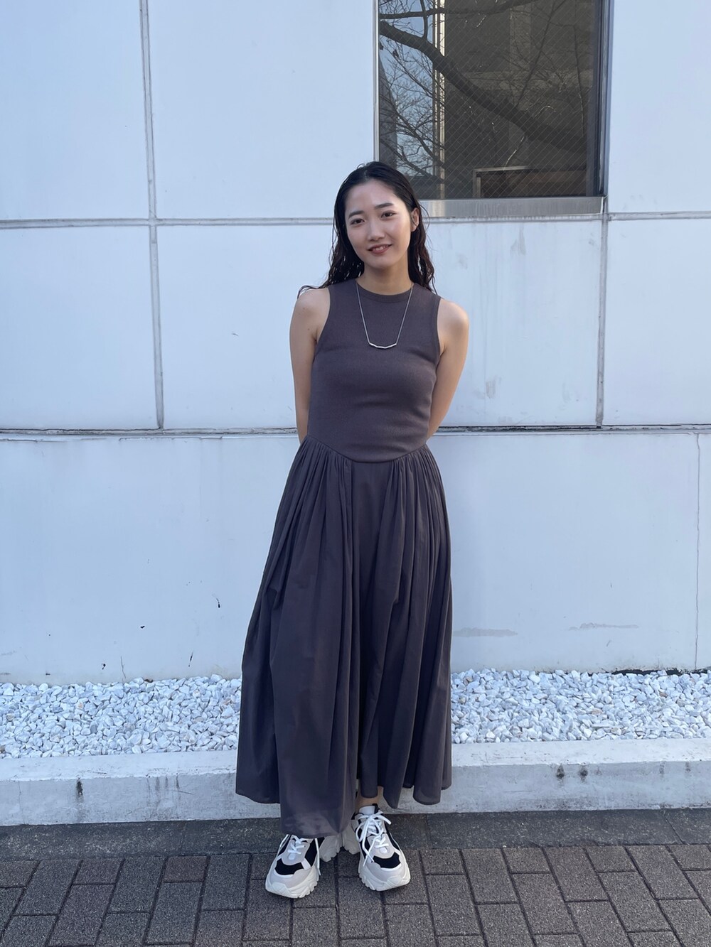 グレー系のワンピース、ブラック系のスニーカーを着用したレディースの春コーディネートの2枚目の写真