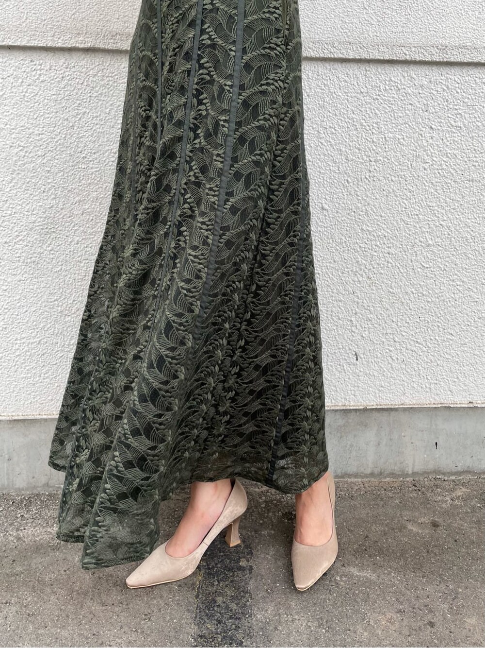 グリーン系のドレス、ベージュ系のパンプス、ブラウン系のクラッチバッグを着用したレディースの夏コーディネートの5枚目の写真