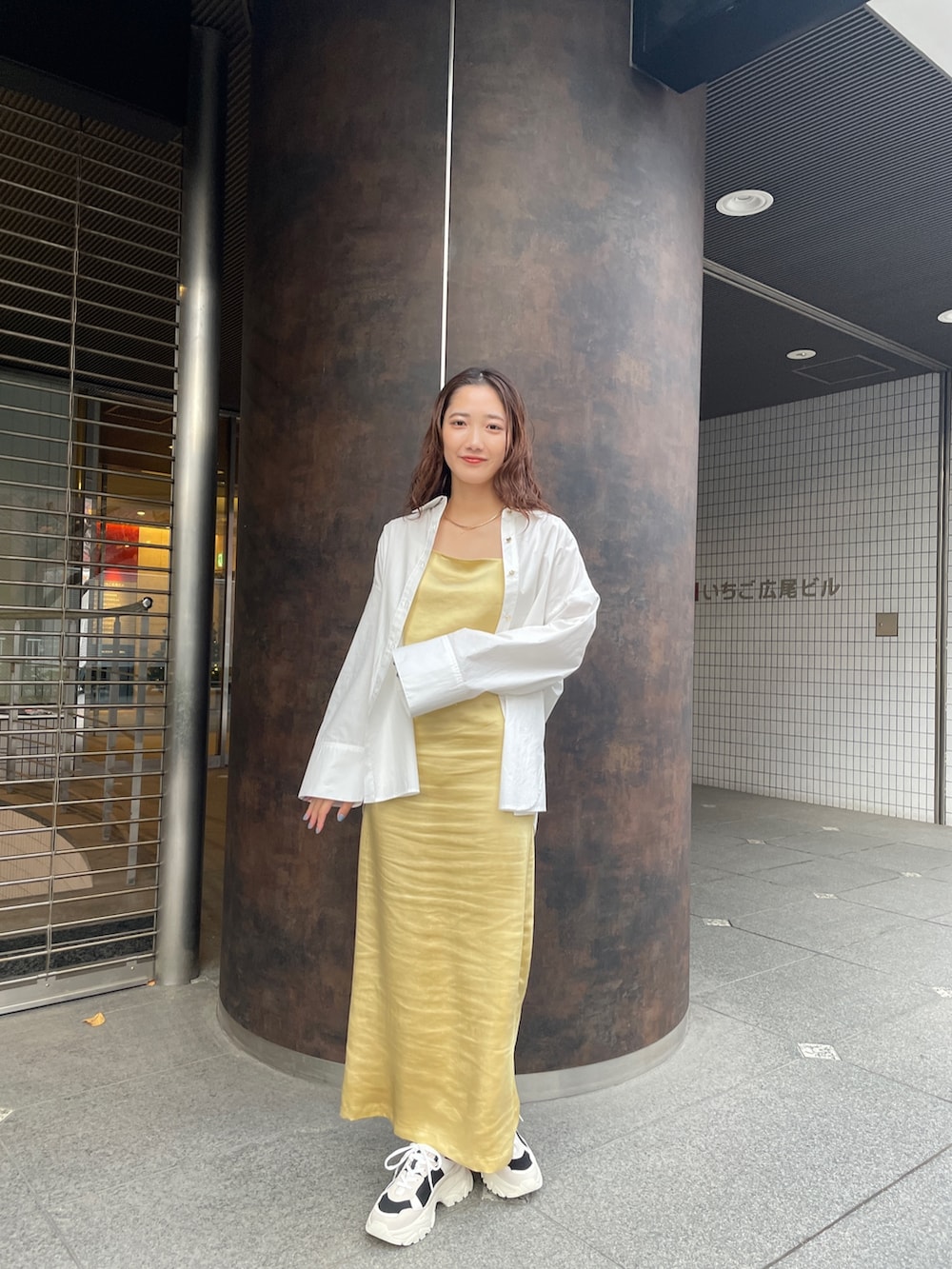 ブラック系のスニーカー、ホワイト系のシャツ/ブラウス、イエロー系のワンピースを着用したレディースの冬コーディネートの2枚目の写真