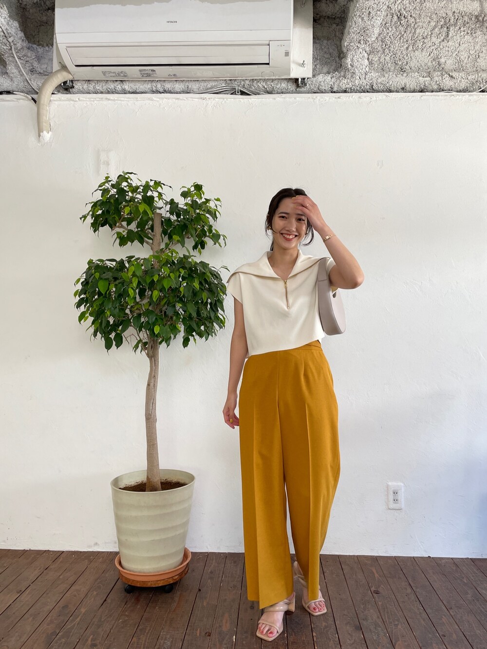 ベージュ系のサンダル、ホワイト系のニット/セーター、イエロー系のスラックスを着用したレディースの春コーディネートの2枚目の写真