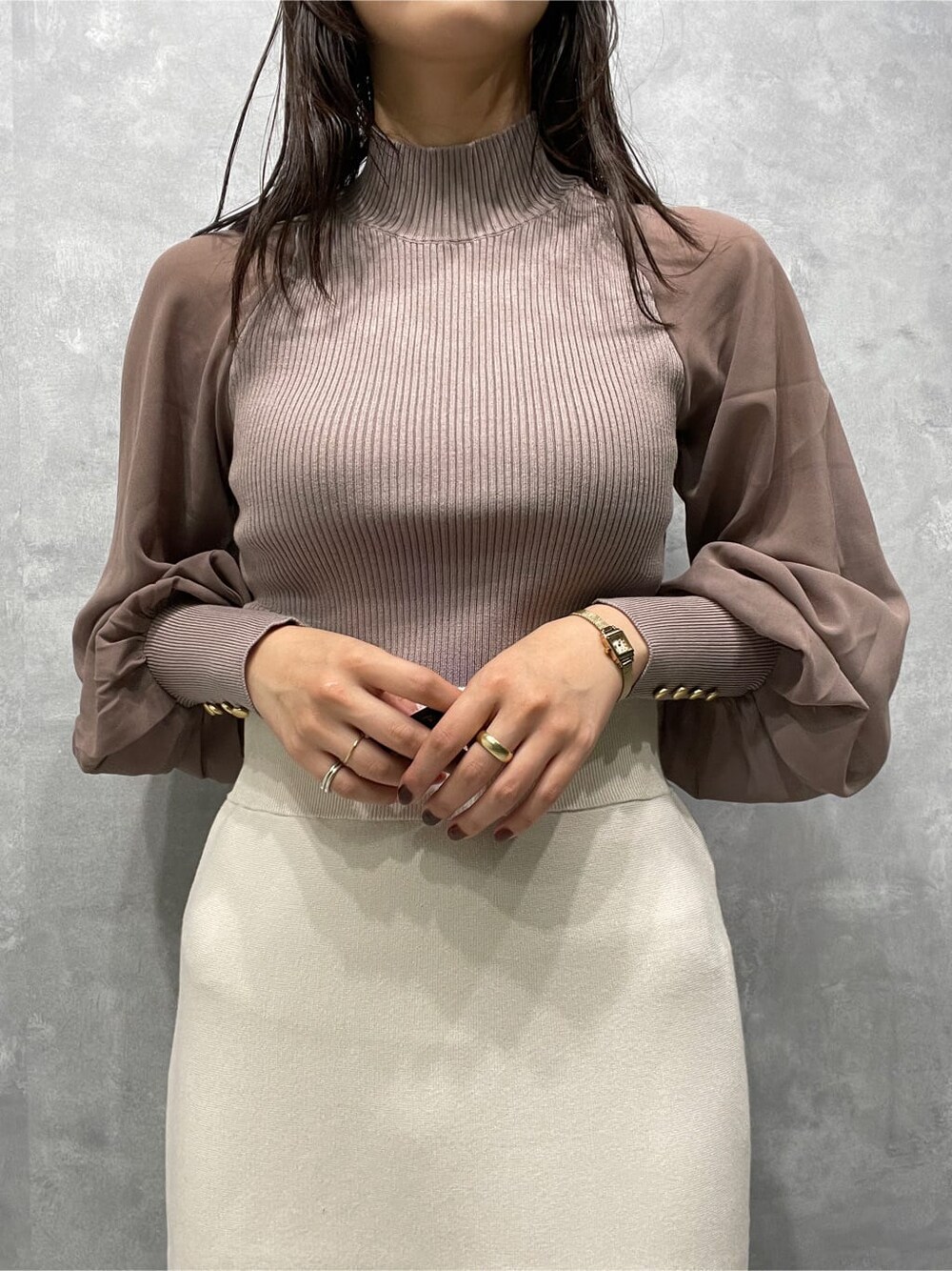 ベージュ系のブーツ、ベージュ系のニット/セーター、ホワイト系のスカートを着用したレディースの秋コーディネートの6枚目の写真