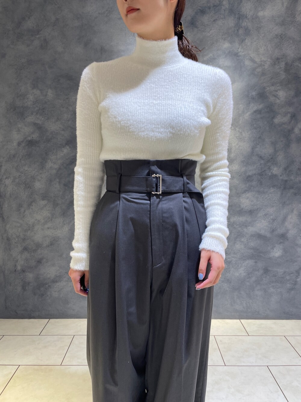 グレー系のその他パンツ、ホワイト系のニット/セーター、ホワイト系のブーツを着用したレディースの冬コーディネートの8枚目の写真