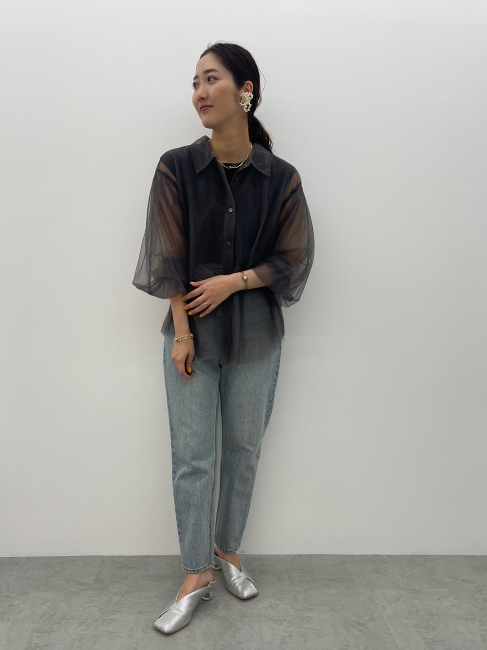 ブルー系のデニムパンツ、シルバー系のパンプス、ブラック系のニット/セーターを着用したレディースの夏コーディネートの3枚目の写真