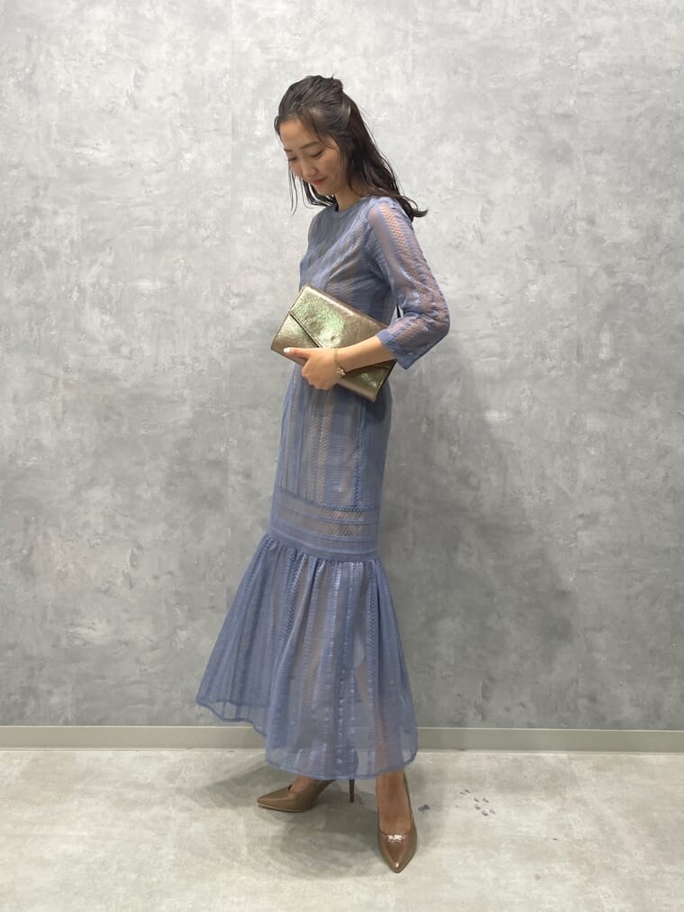 ゴールド系のパンプス、ゴールド系のクラッチバッグ、ブルー系のドレスを着用したレディースの夏コーディネートの3枚目の写真