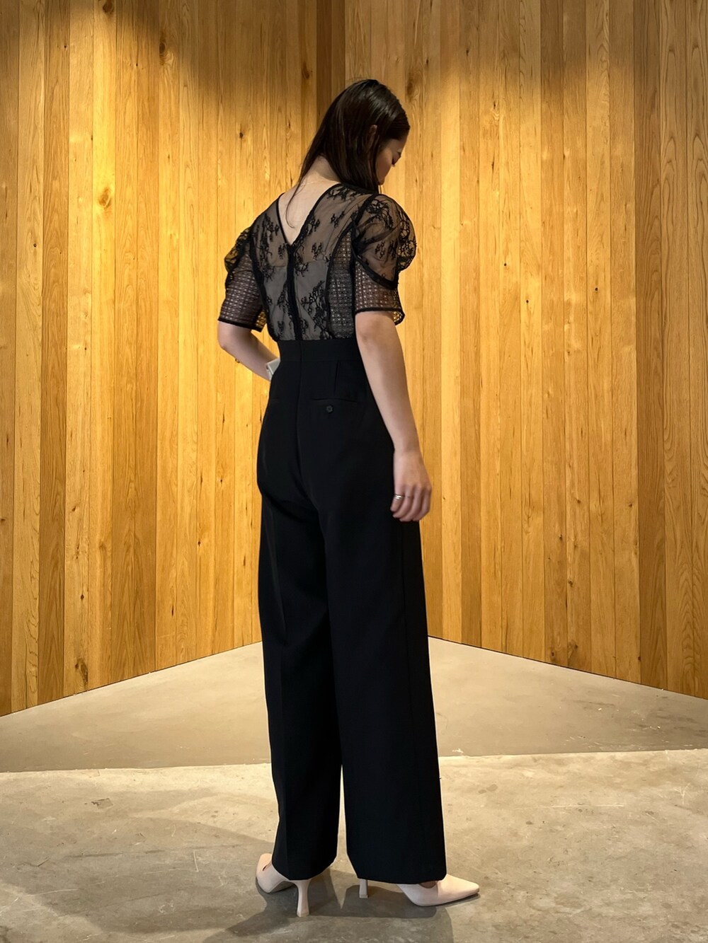 ベージュ系のパンプス、ベージュ系のクラッチバッグ、ブラック系のパンツドレスを着用したレディースの冬コーディネートの5枚目の写真