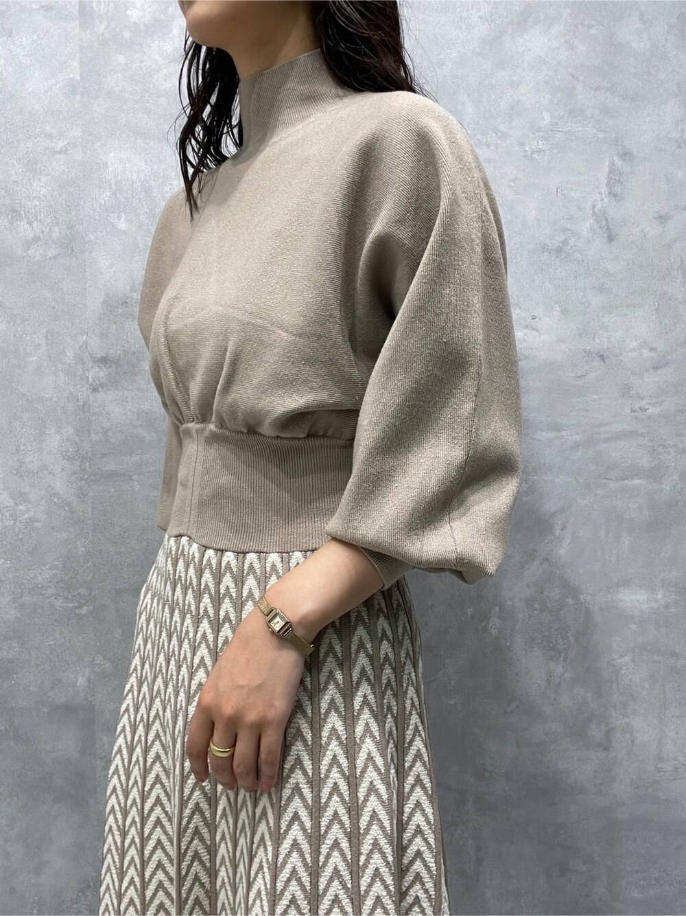 ホワイト系のノーカラーコート、ブラック系のブーツ、ベージュ系のワンピースを着用したレディースの秋コーディネートの7枚目の写真