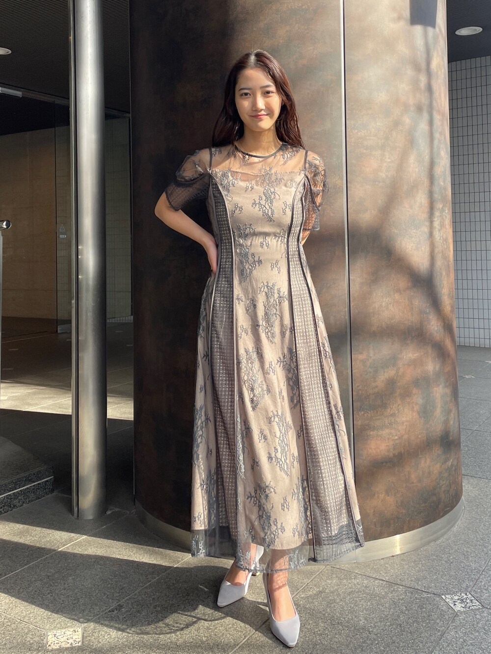 グレー系のドレス、グレー系のパンプス、ホワイト系のトレンチコートを着用したレディースの冬コーディネートの5枚目の写真