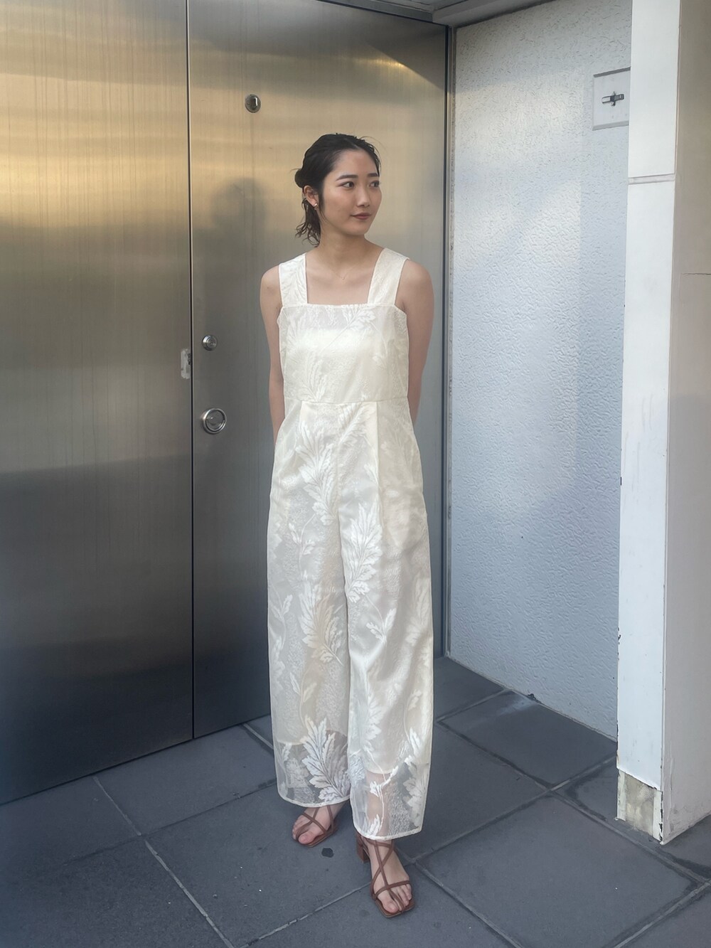 ブラウン系のサンダル、ホワイト系のつなぎ/オールインワン、ベージュ系の折りたたみ傘を着用したレディースの冬コーディネートの2枚目の写真