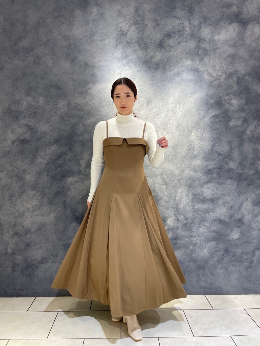 ベージュ系のワンピース、ホワイト系のニット/セーター、ホワイト系のブーツを着用したレディースの冬コーディネートの4枚目の写真