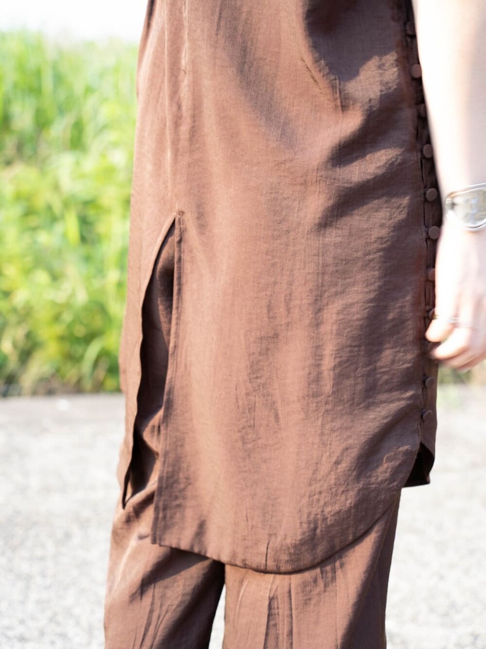 ブラウン系のワンピース、シルバー系のバングル/リストバンドを着用したレディースの夏コーディネートの4枚目の写真