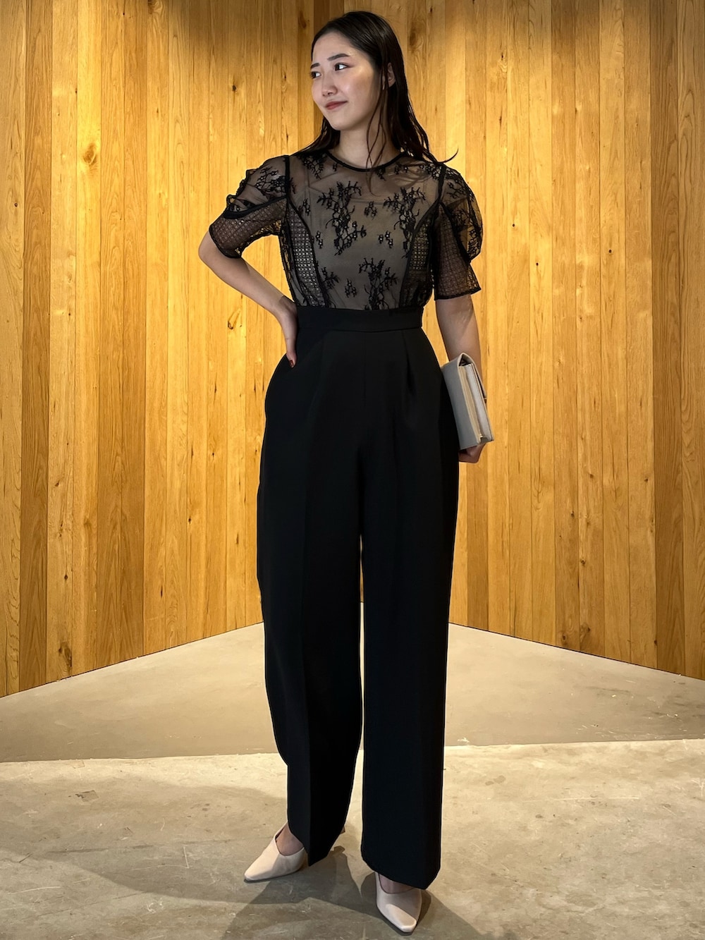 ベージュ系のパンプス、ベージュ系のクラッチバッグ、ブラック系のパンツドレスを着用したレディースの冬コーディネートの2枚目の写真