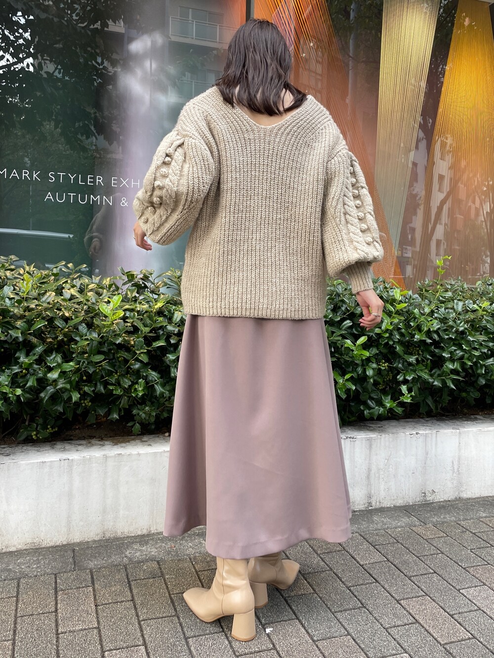 ホワイト系のニット/セーター、ホワイト系のその他アウター、ベージュ系のスカートを着用したレディースの秋コーディネートの5枚目の写真