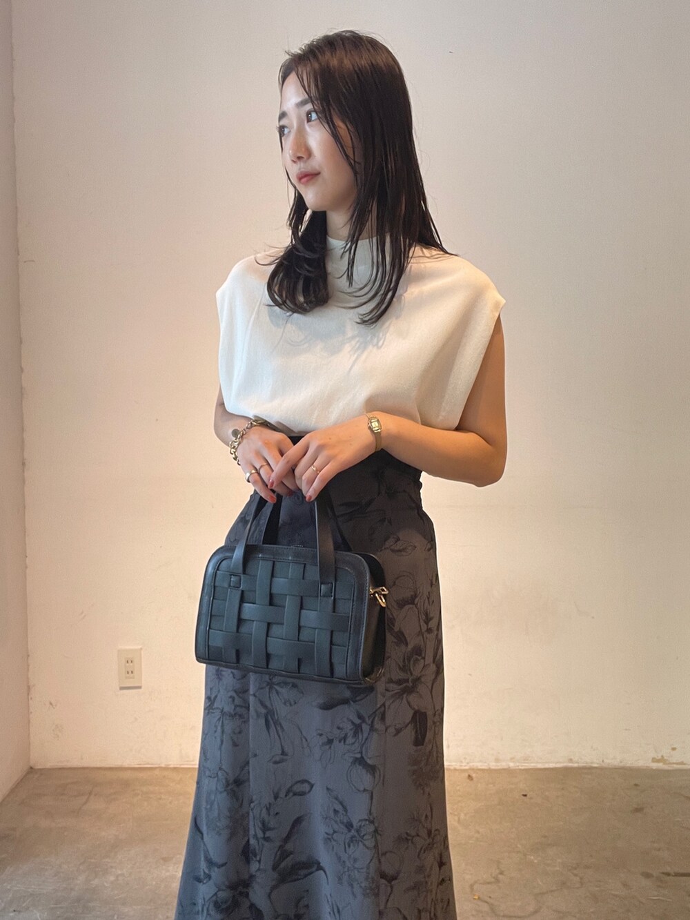 ホワイト系のニット/セーター、ブラック系のショルダーバッグ、イエロー系のサンダルを着用したレディースの夏コーディネートの7枚目の写真