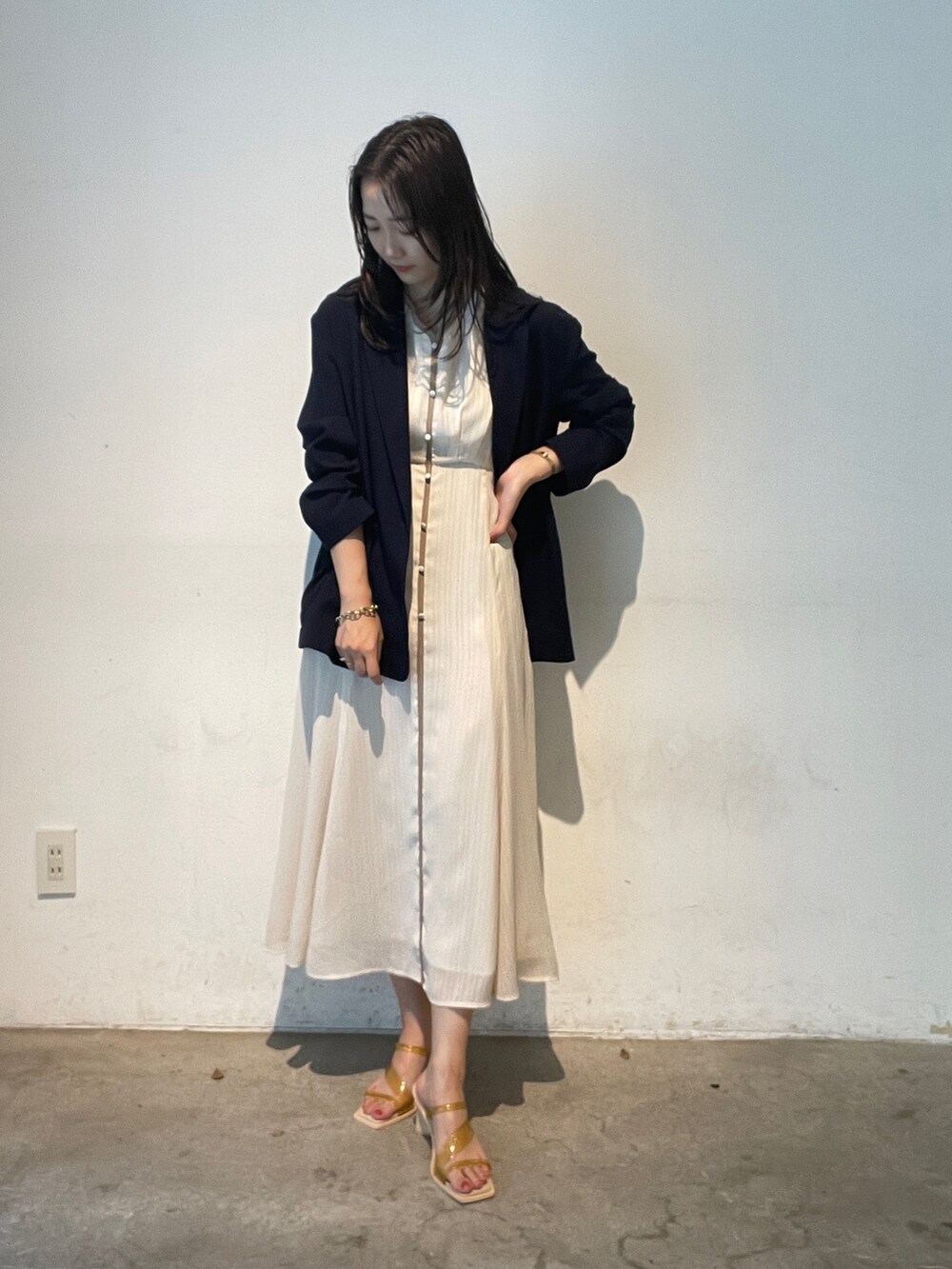 イエロー系のサンダル、ブルー系のテーラードジャケット、ホワイト系のワンピースを着用したレディースの夏コーディネートの2枚目の写真