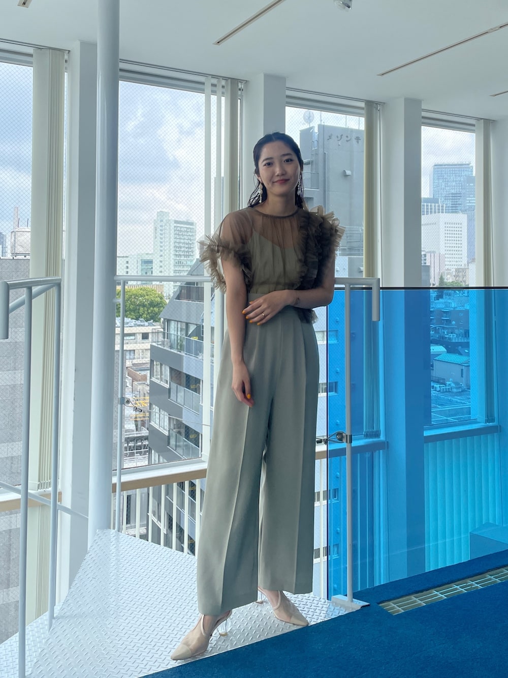 グリーン系のパンツドレス、ベージュ系のパンプスを着用したレディースの春コーディネートの5枚目の写真