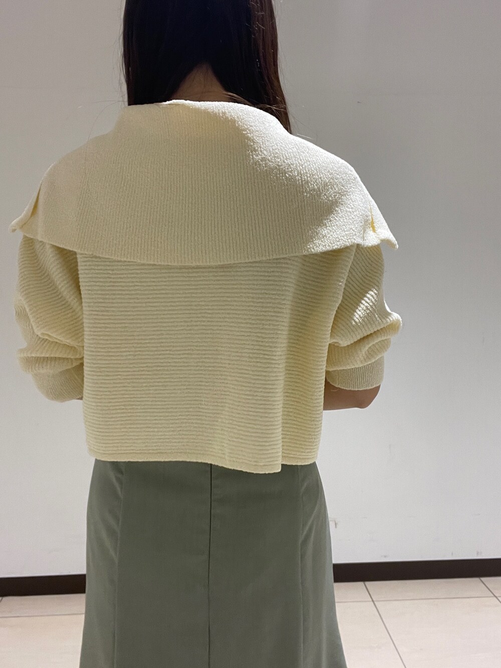 ホワイト系のカーディガン/ボレロ、グリーン系のスカートを着用したレディースの春コーディネートの7枚目の写真