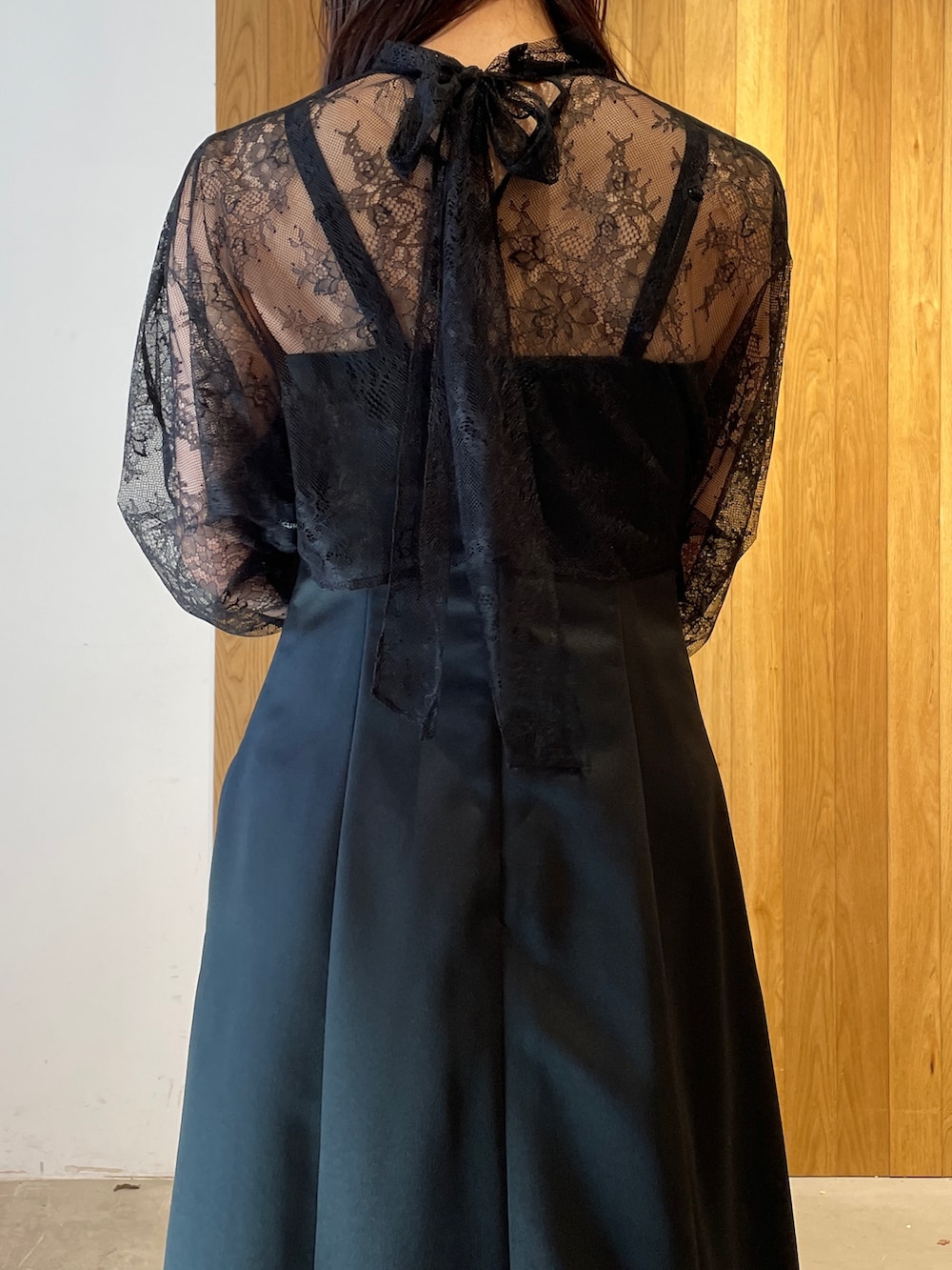 グレー系のパンプス、ブラック系のドレス、グレー系のクラッチバッグを着用したレディースの冬コーディネートの5枚目の写真