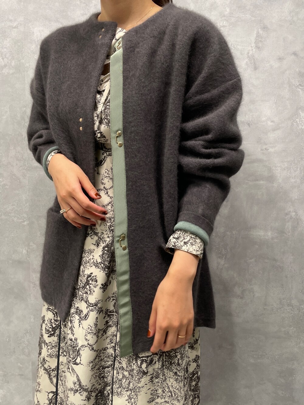 グレー系のカーディガン/ボレロ、ホワイト系のワンピース、ブラック系のブーツを着用したレディースの冬コーディネートの4枚目の写真