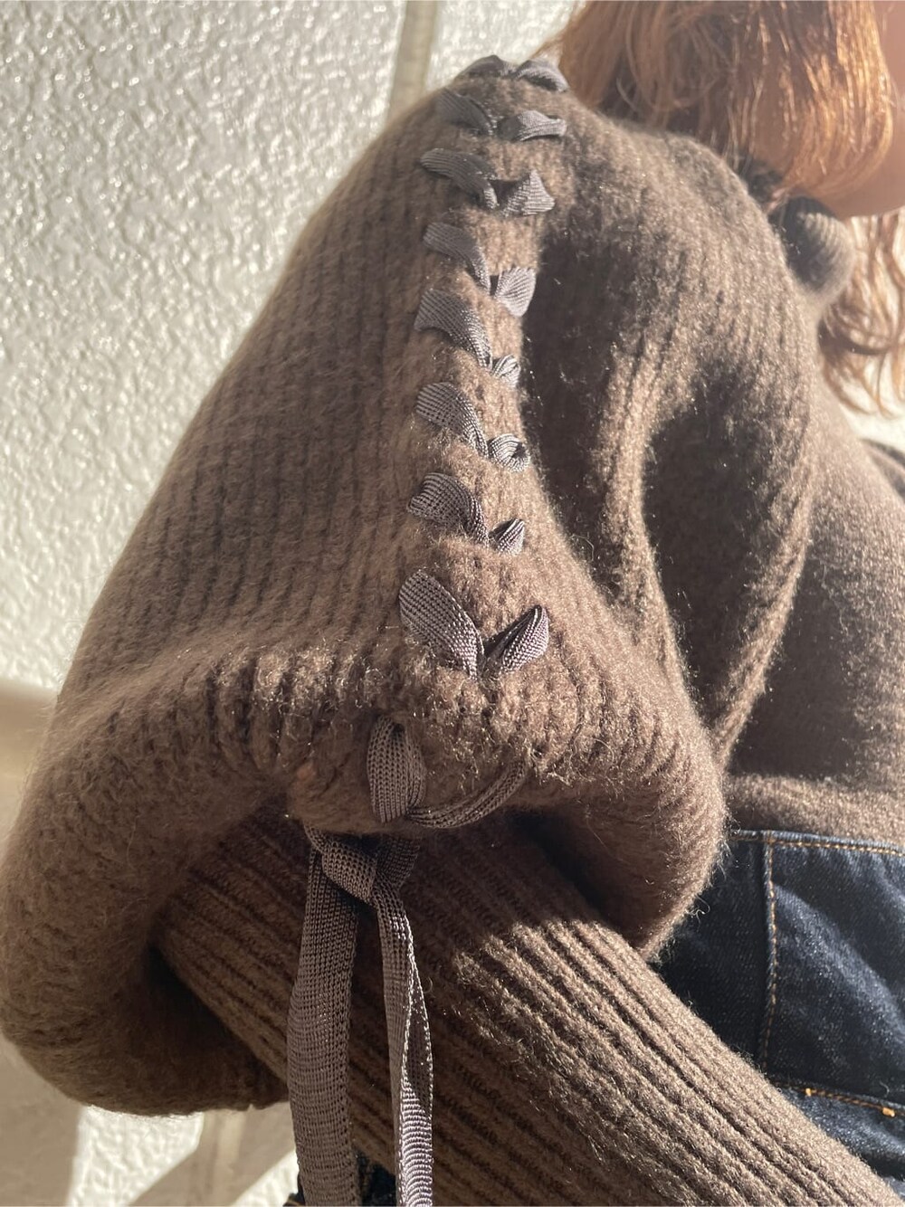 ホワイト系のその他シューズ、ブラウン系のニット/セーター、ブルー系のデニムパンツを着用したレディースの冬コーディネートの6枚目の写真