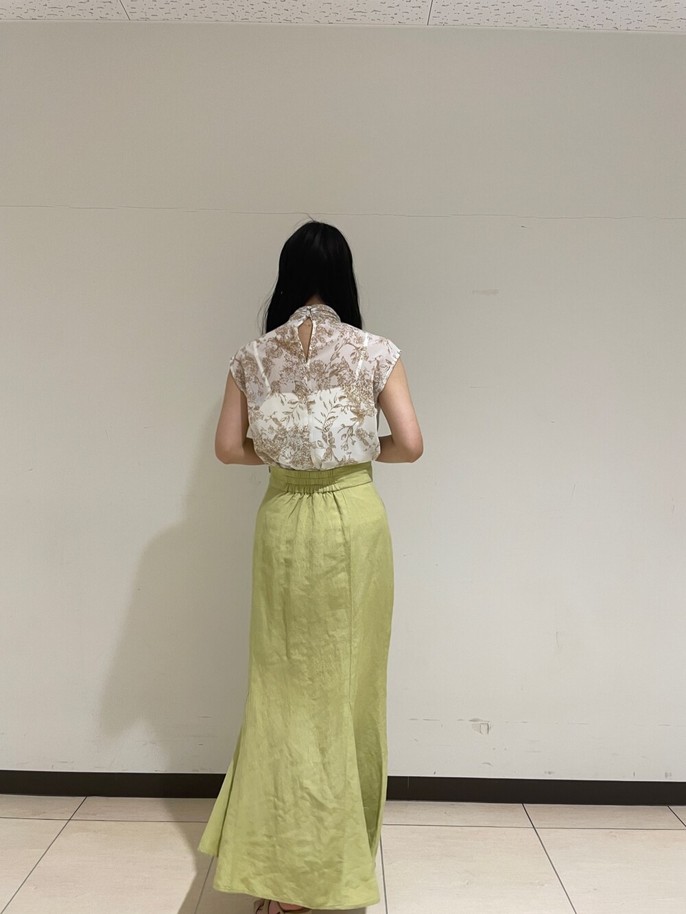 ベージュ系のシャツ/ブラウス、グリーン系のスカート、ベージュ系のサンダルを着用したレディースの春コーディネートの6枚目の写真