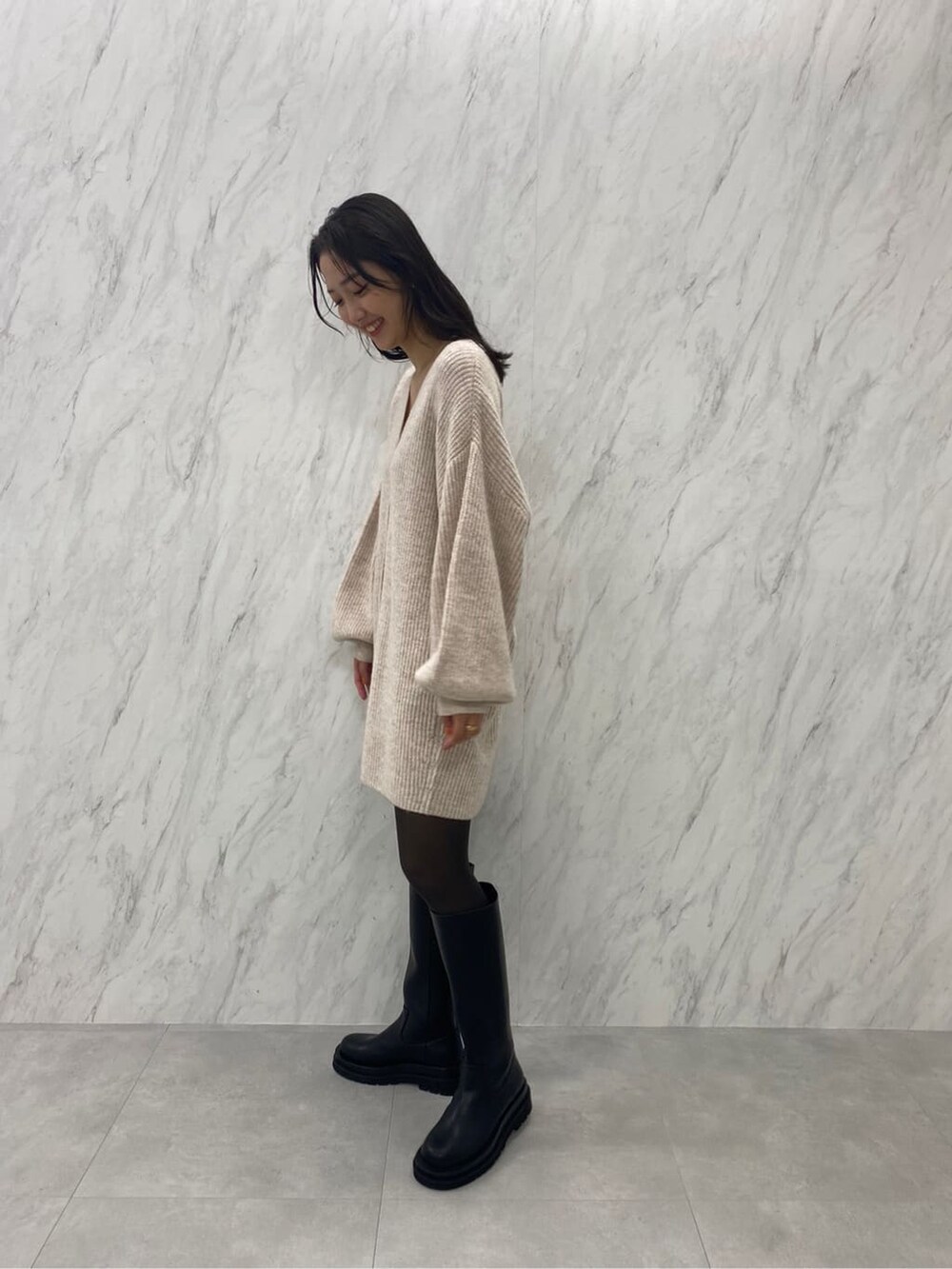 ブラック系のブーツ、ホワイト系のカーディガン/ボレロを着用したレディースの秋コーディネートの5枚目の写真