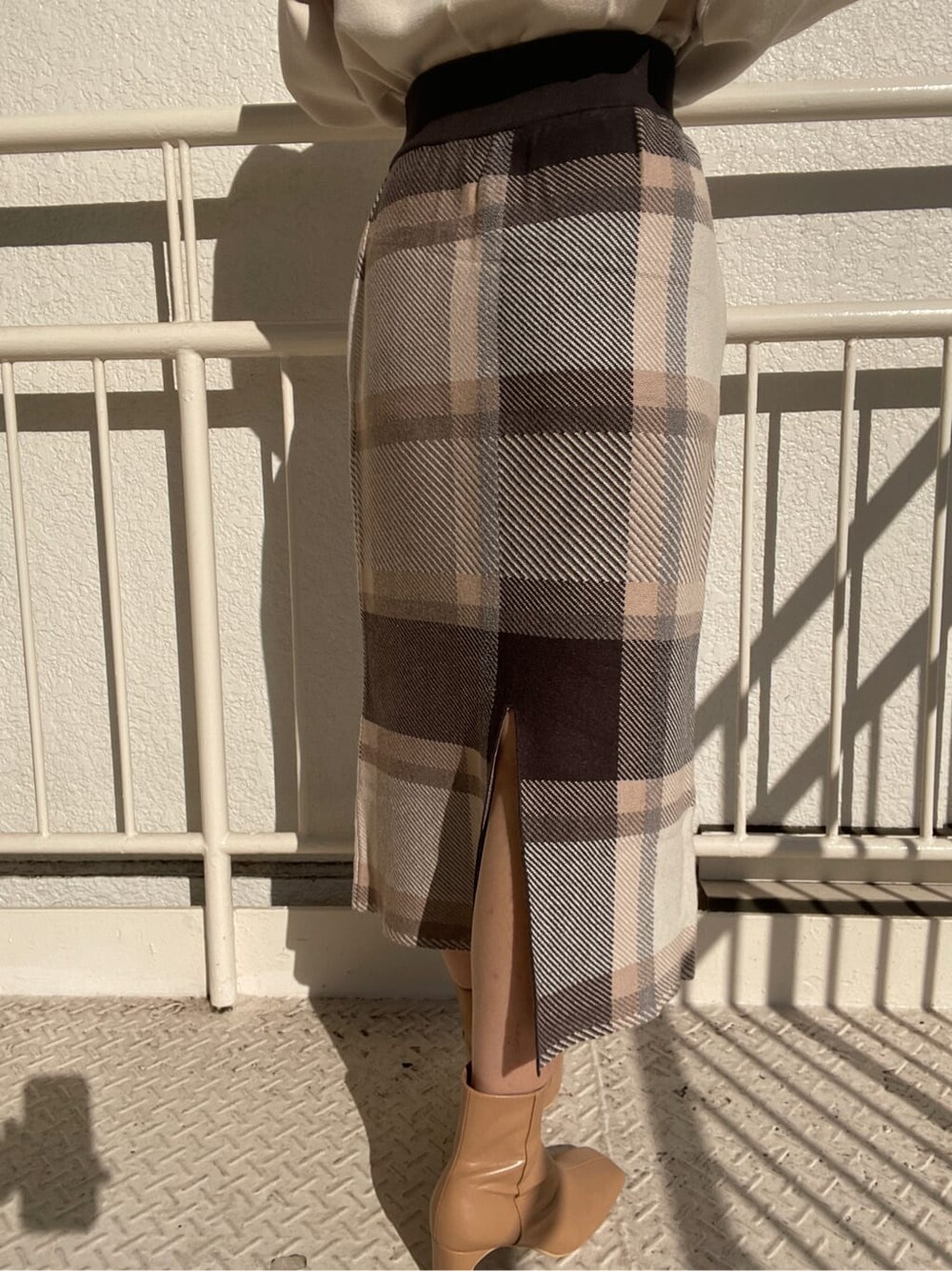 ベージュ系のその他シューズ、グレー系のスカート、ホワイト系のニット/セーターを着用したレディースの冬コーディネートの6枚目の写真