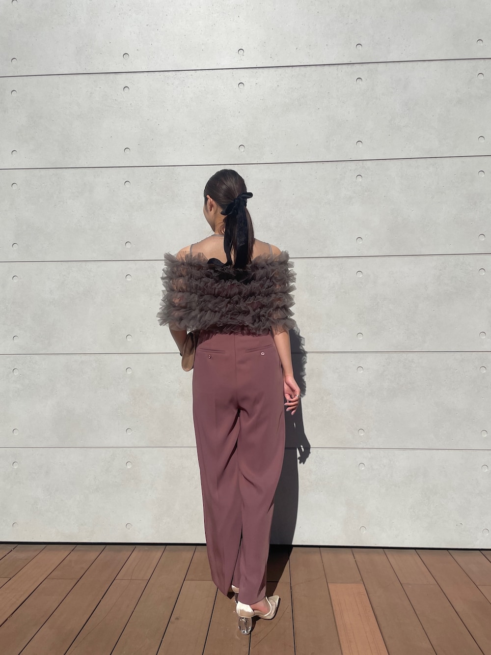 ピンク系のパンツドレス、ゴールド系のハンドバッグ、ベージュ系のパンプスを着用したレディースの秋コーディネートの3枚目の写真