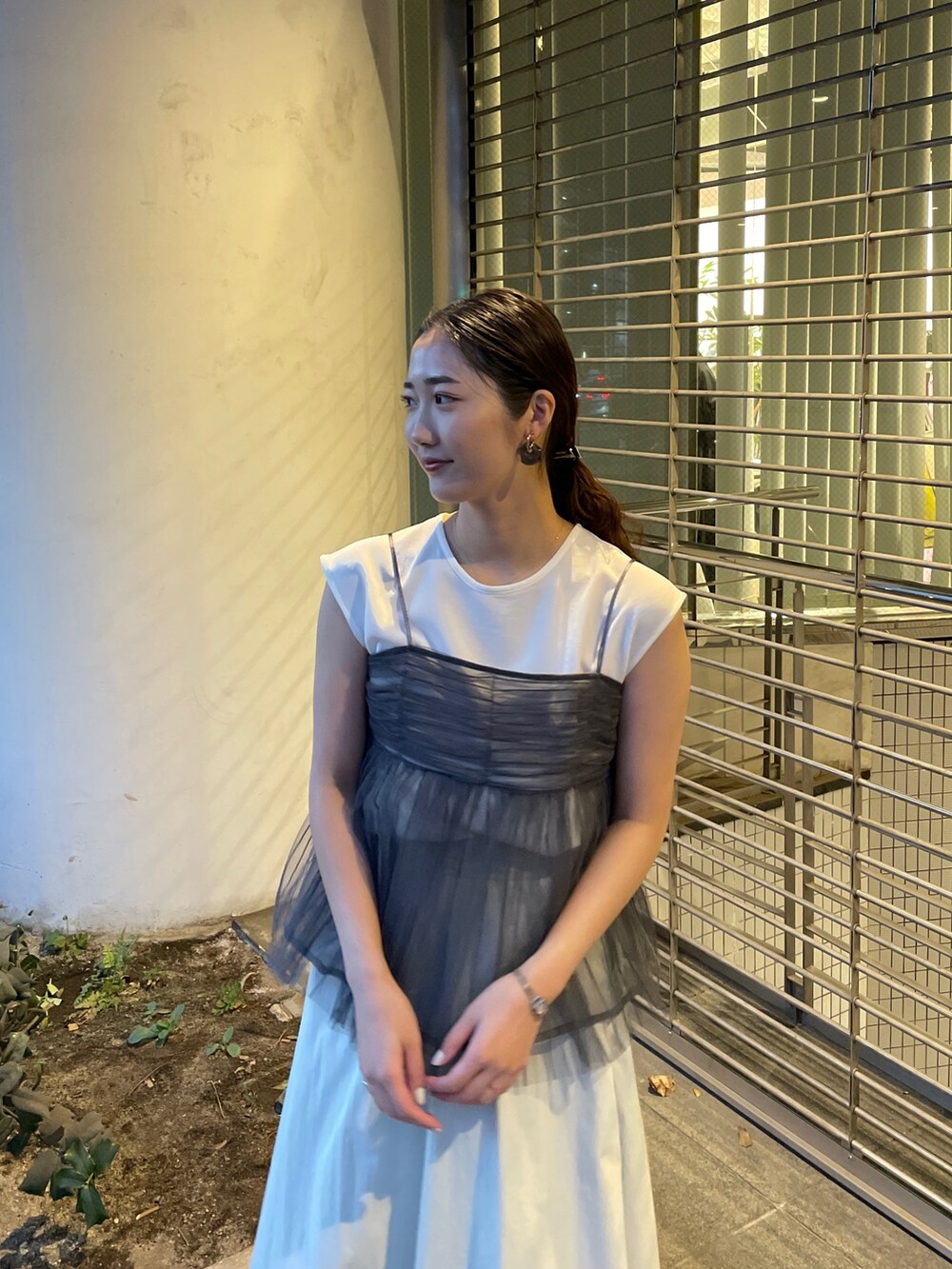 グレー系のTシャツ/カットソー、ホワイト系のスカート、ブラック系のサンダルを着用したレディースの春コーディネートの7枚目の写真