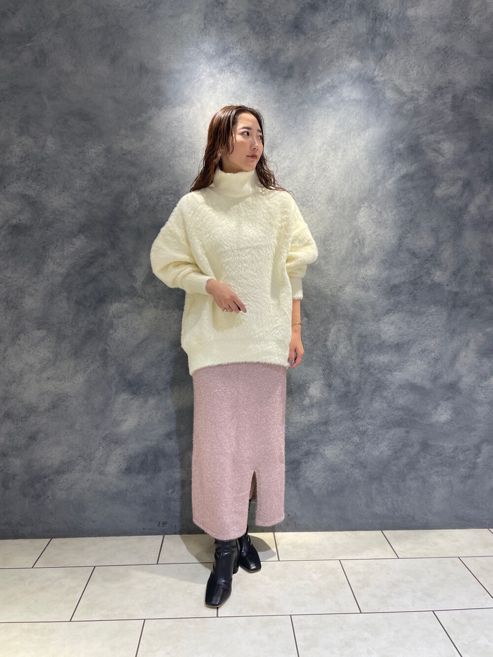 ホワイト系のニット/セーター、ピンク系のスカート、ブラック系のブーツを着用したレディースの秋コーディネートの3枚目の写真