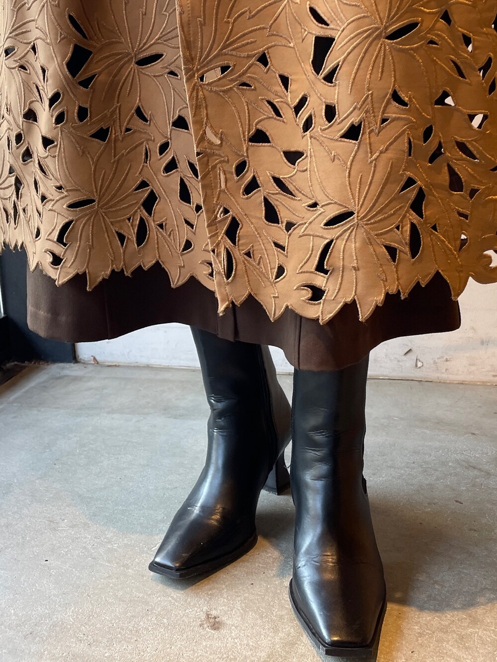 ブラック系のブーツ、ホワイト系のニット/セーター、ブラウン系のジャンパースカートを着用したレディースの冬コーディネートの10枚目の写真