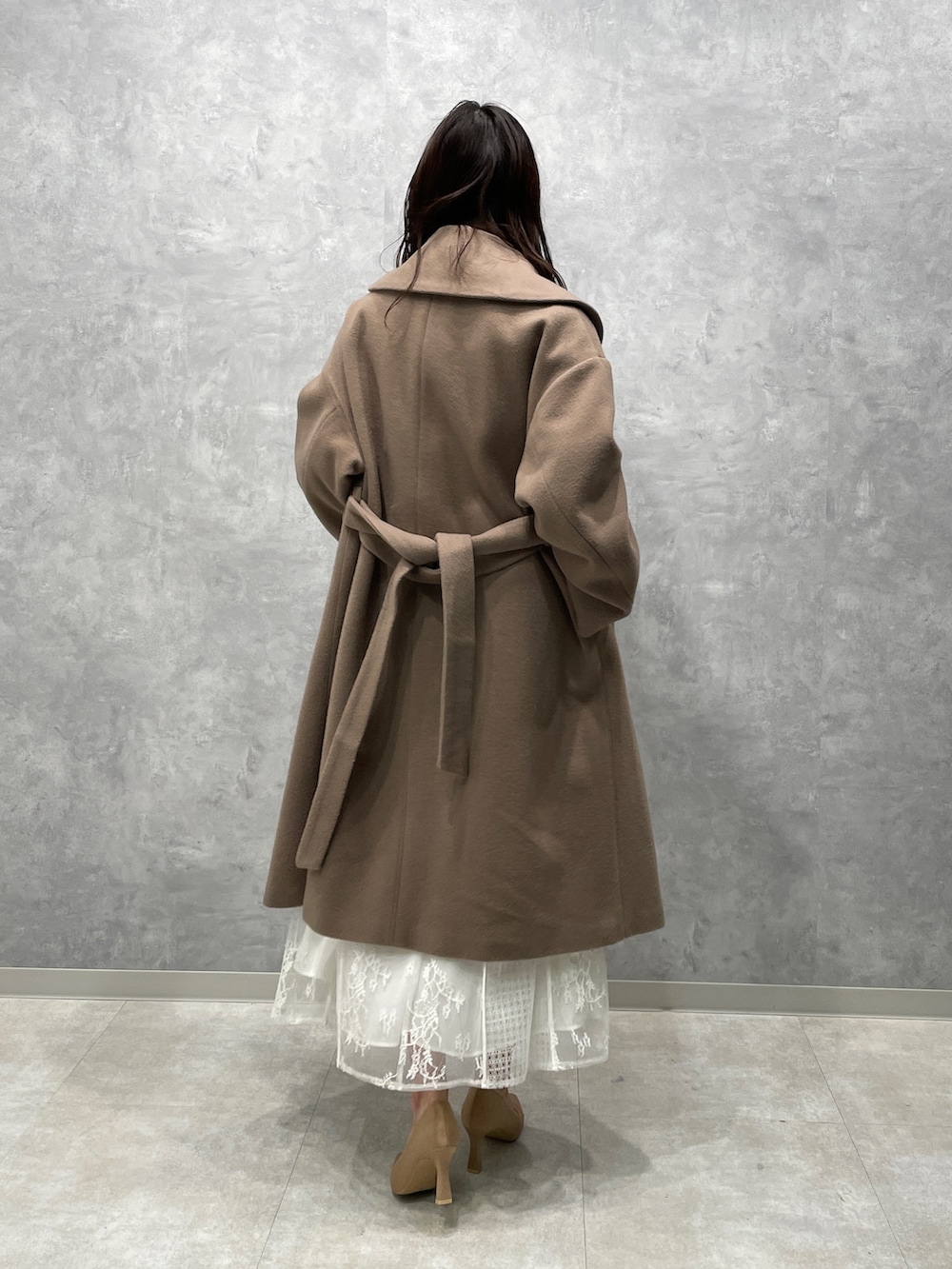 ベージュ系のその他アウター、ゴールド系のパンプス、ホワイト系のドレスを着用したレディースの冬コーディネートの3枚目の写真