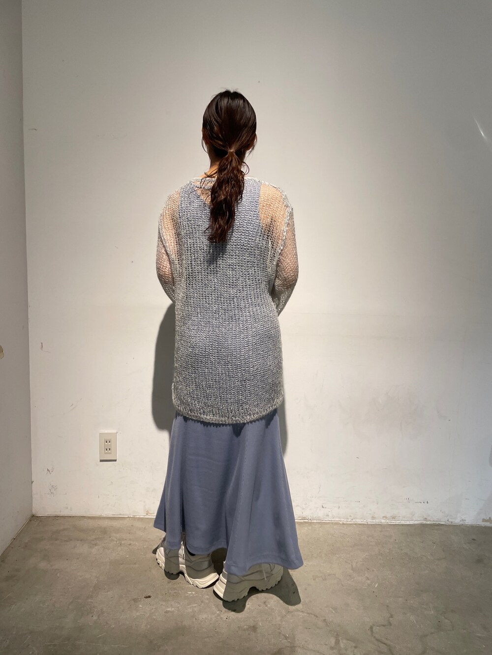 ホワイト系のスニーカー、ブルー系のニット/セーター、ブルー系のワンピースを着用したレディースの春コーディネートの6枚目の写真