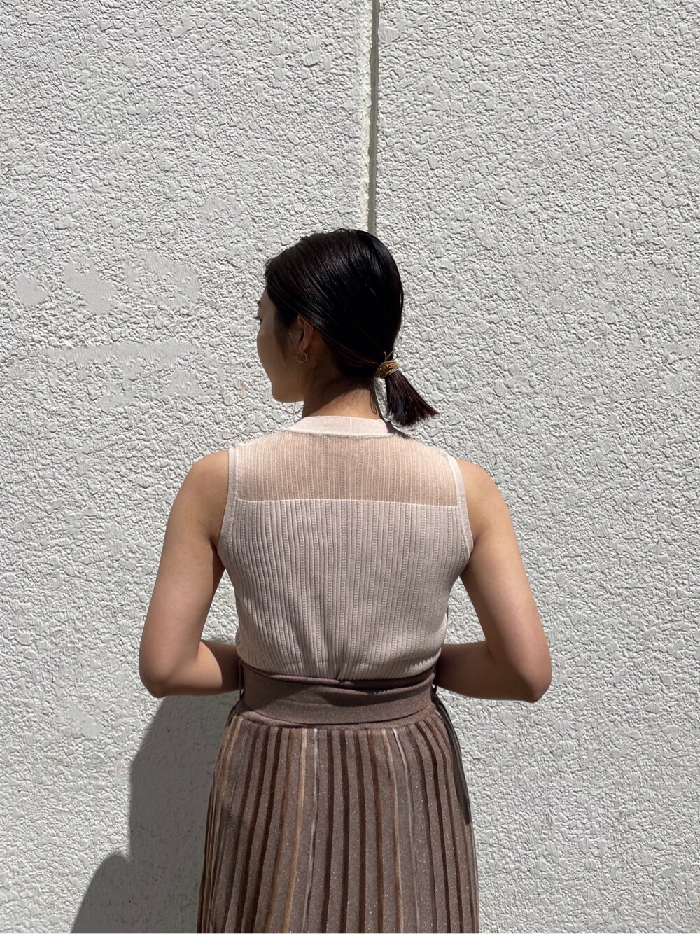 グリーン系のサンダル、ブラウン系のスカート、ホワイト系のニット/セーターを着用したレディースの春コーディネートの3枚目の写真