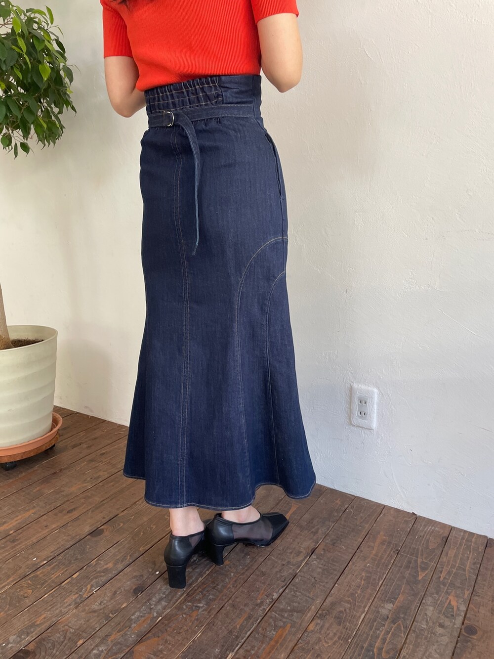 オレンジ系のニット/セーター、ブルー系のデニムスカート、ブラック系のパンプスを着用したレディースの春コーディネートの8枚目の写真