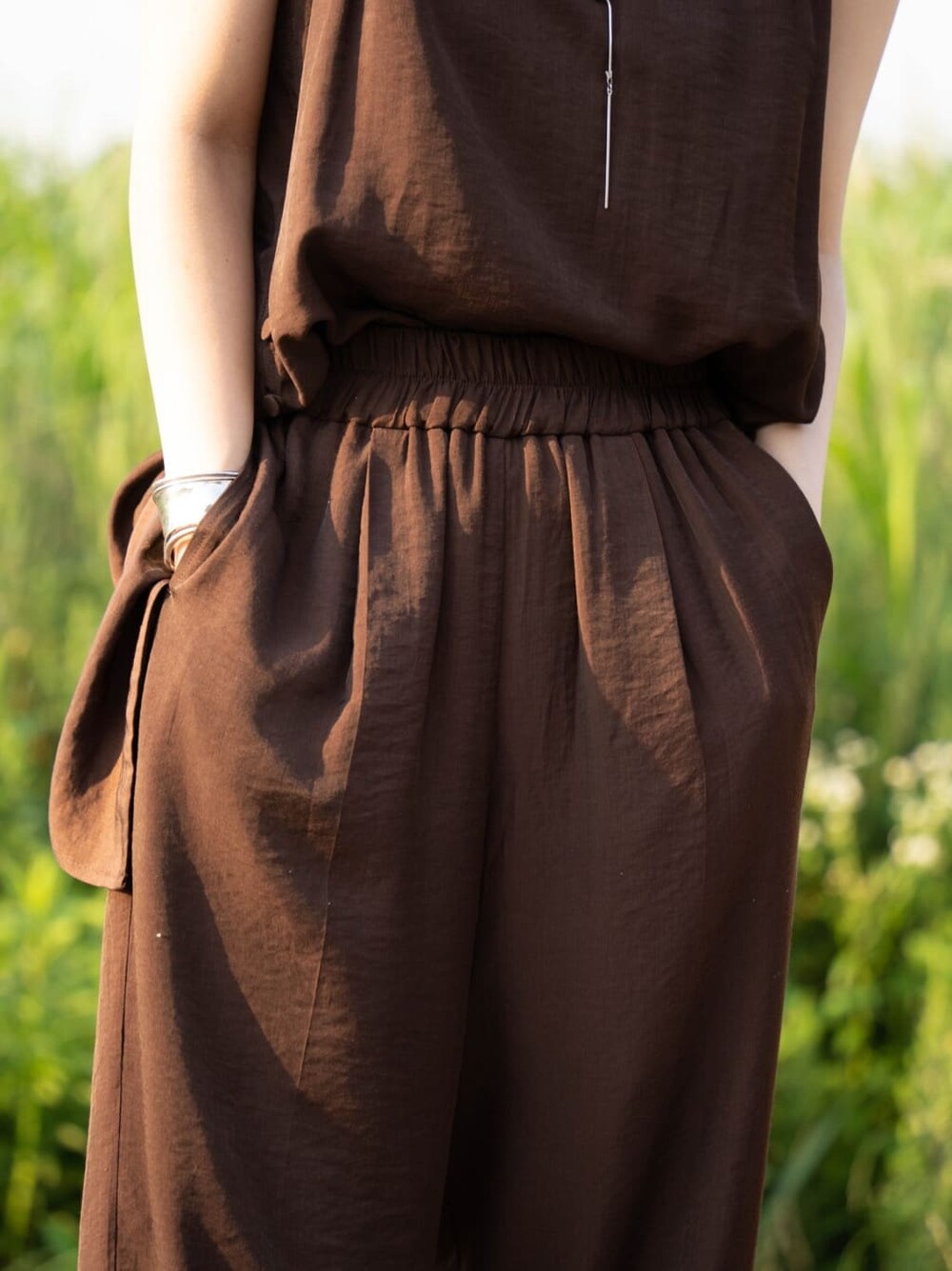 ブラウン系のワンピース、シルバー系のバングル/リストバンドを着用したレディースの夏コーディネートの5枚目の写真