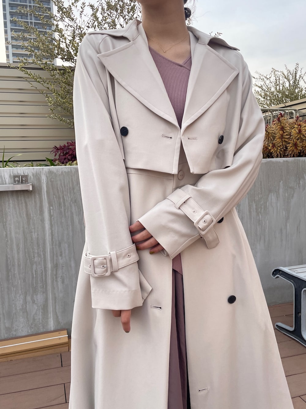 ホワイト系のトレンチコート、ブラック系のパンプス、ピンク系のワンピースを着用したレディースの冬コーディネートの6枚目の写真