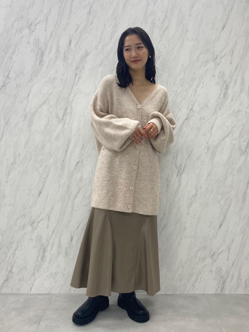ブラック系のブーツ、ベージュ系のスカート、ホワイト系のカーディガン/ボレロを着用したレディースの秋コーディネートの4枚目の写真