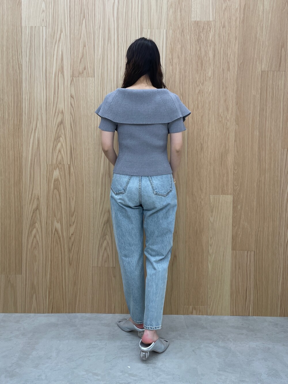 ブルー系のデニムパンツ、グレー系のニット/セーター、シルバー系のパンプスを着用したレディースの春コーディネートの4枚目の写真