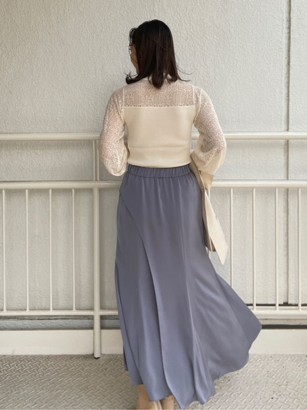 ホワイト系のニット/セーター、ベージュ系のブーツ、ブルー系のスカートを着用したレディースの春コーディネートの8枚目の写真