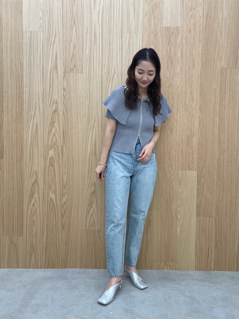 ブルー系のデニムパンツ、グレー系のニット/セーター、シルバー系のパンプスを着用したレディースの春コーディネートの2枚目の写真