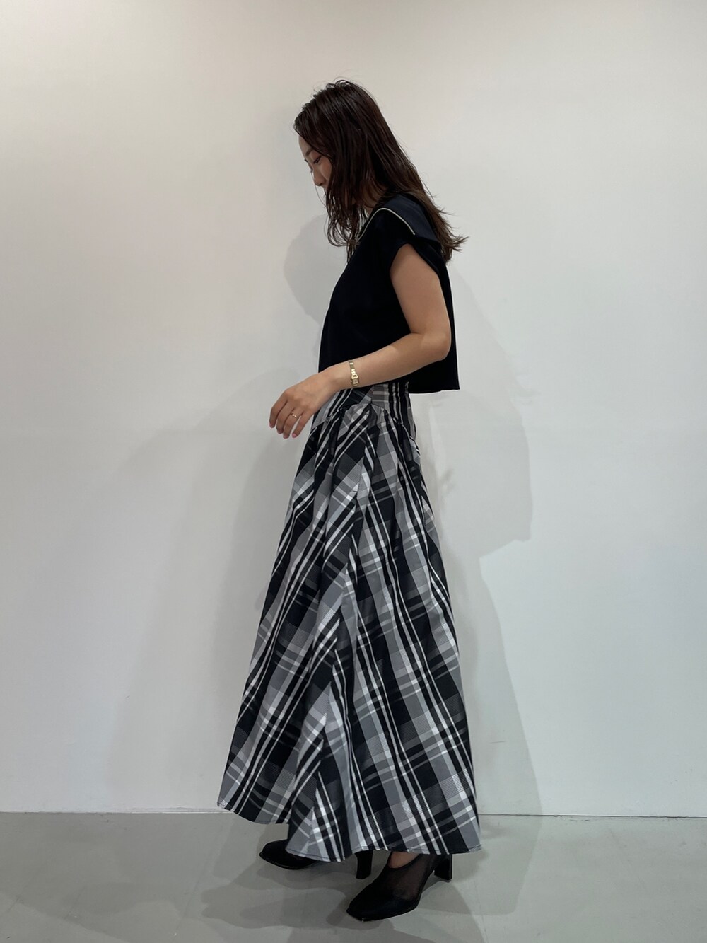 ブラック系のTシャツ/カットソー、ブラック系のパンプス、ホワイト系のスカートを着用したレディースの夏コーディネートの5枚目の写真